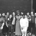 A black and white photo of a group of people posing for a photo.
