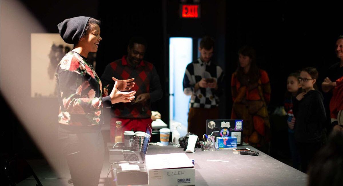 A woman is standing in front of a group of people.