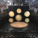 The stage of a theater with several circular lights on it.