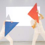 Two people holding colorful triangles.